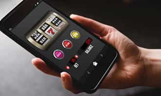 Uno smartphone con un gioco slot sullo sfondo e un QR code.