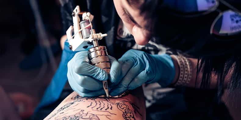 Tatuatore disegna su un braccio