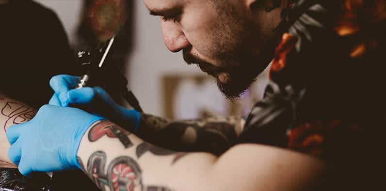 Tattoo Artist Tattooing his Client.