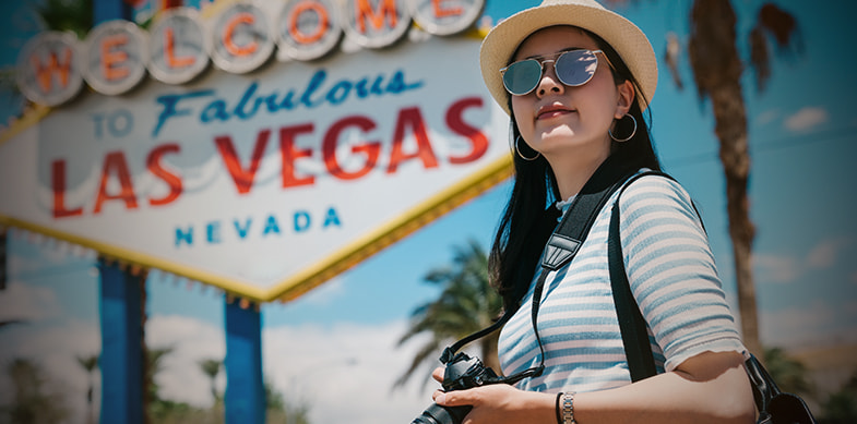 una turista davanti l'insegna di Las Vegas
