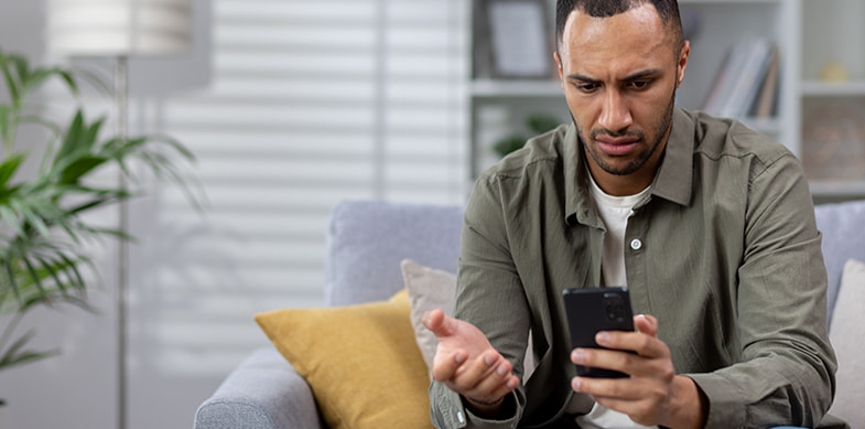 Uomo triste con smartphone in mano