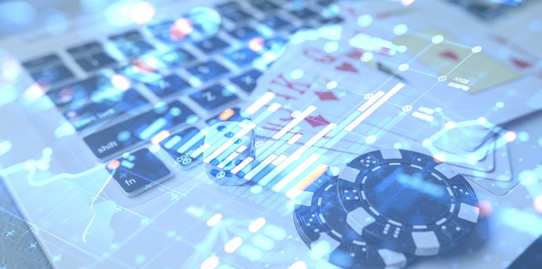 Laptop, fiches da casinò e carte da poker